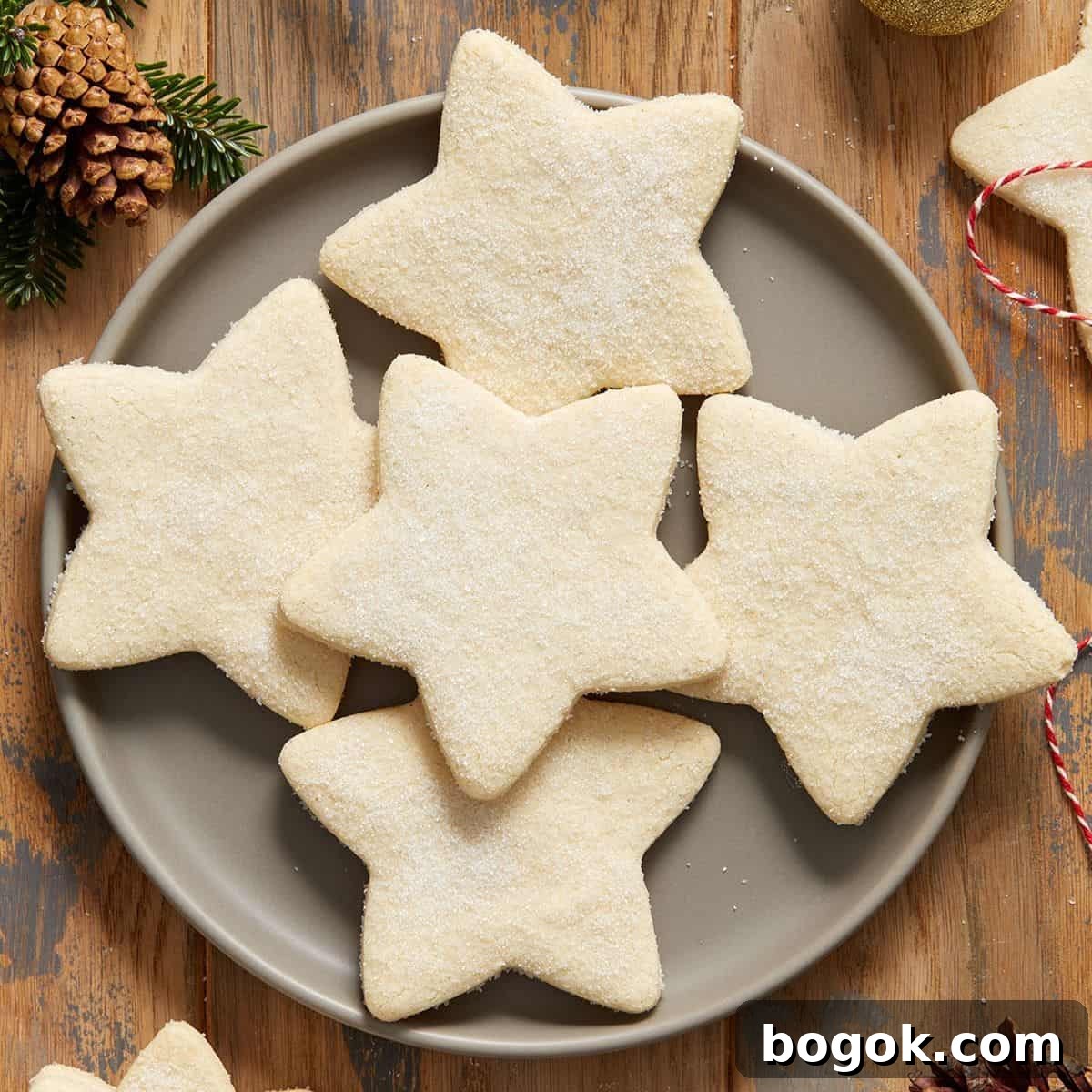 Round grey plate with five shortbread cookies, and some decorations around the edge of the photo.