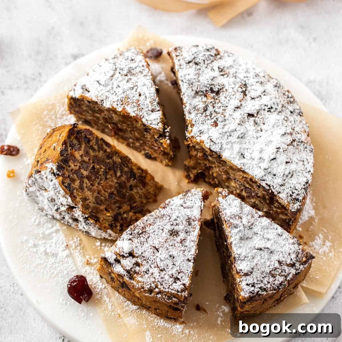 Whole cake which has been cut into slices, sitting on a white dish.