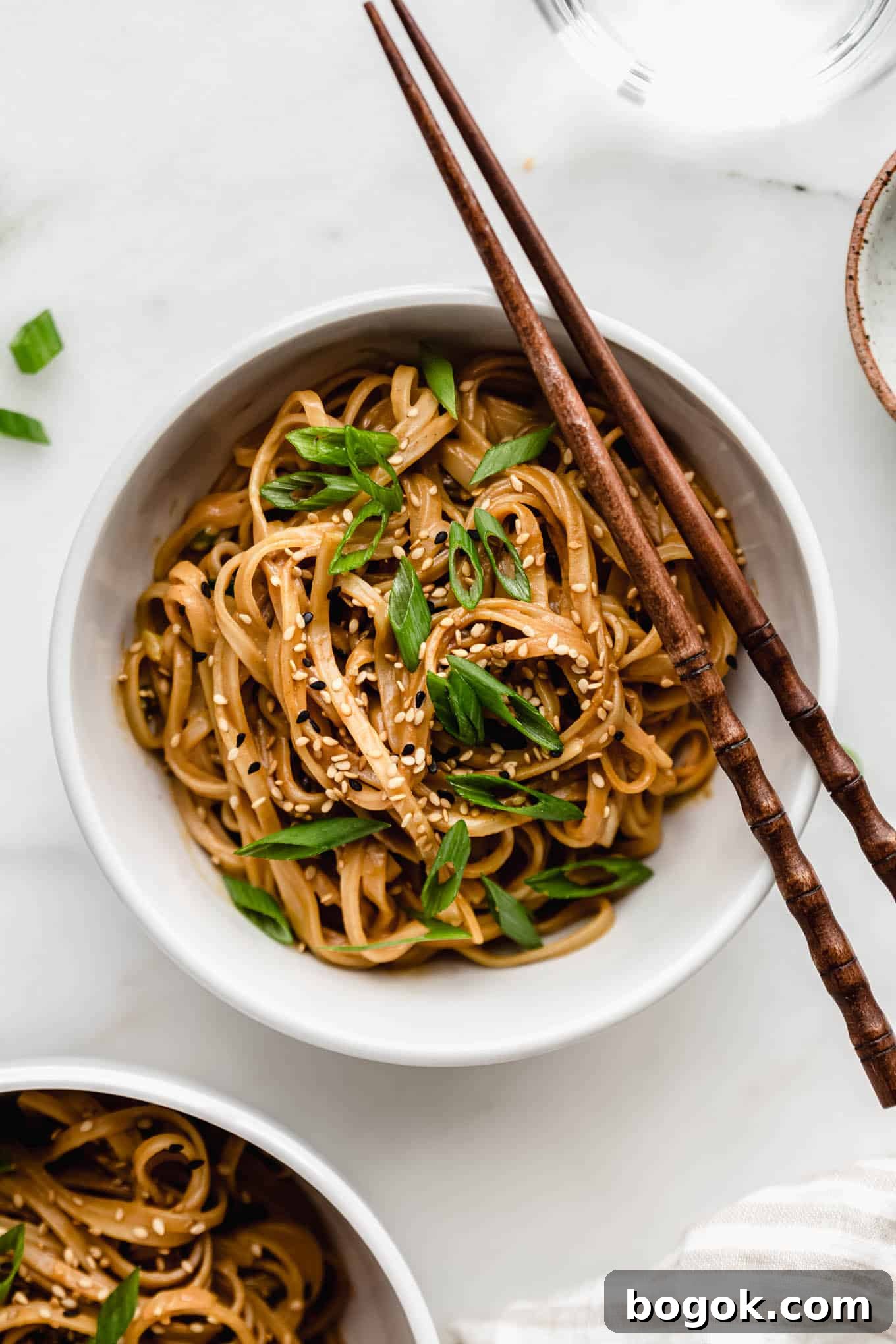 Creamy Peanut Butter Noodles Recipe with Garlic and Soy 2 A bowl of peanut butter noodles with wooden chopsticks on the side