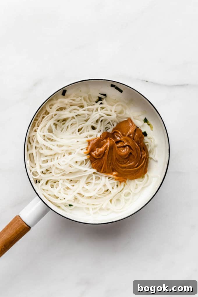 Creamy Peanut Butter Noodles Recipe with Garlic and Soy 6 Rice noodles and peanut sauce in a white pot