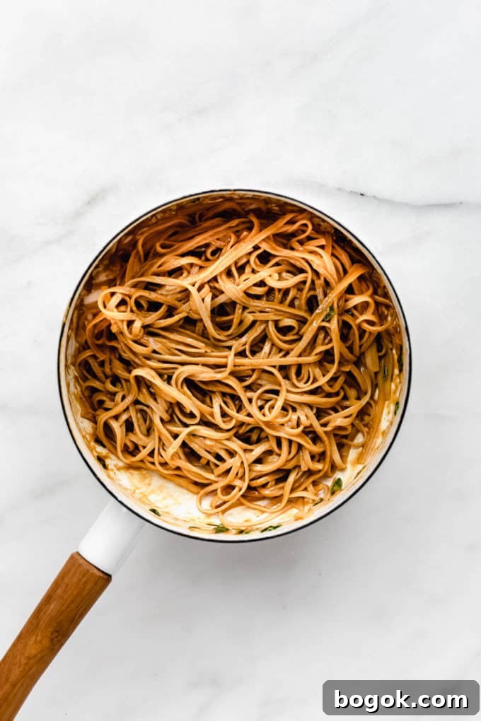 Creamy Peanut Butter Noodles Recipe with Garlic and Soy 7 Peanut butter noodles in a white pot with a wood handle