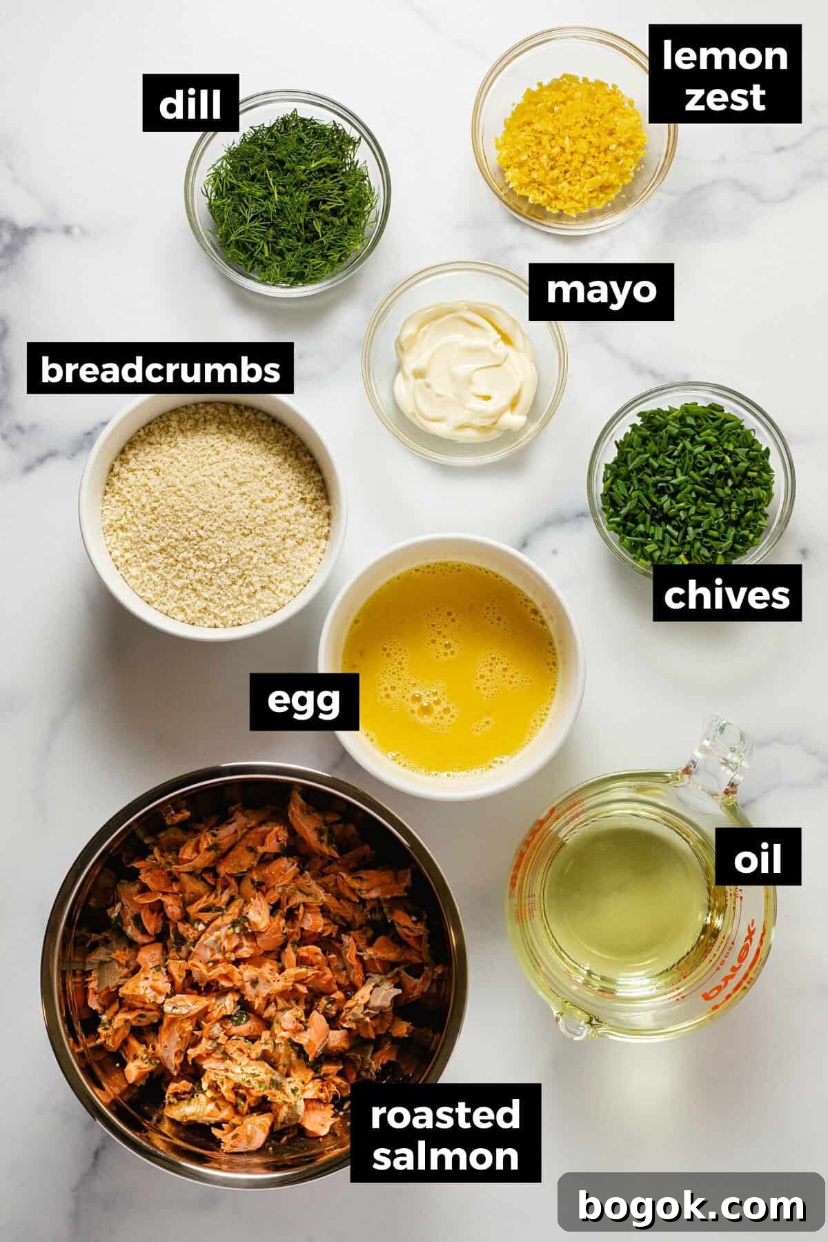 Marble counter top with bowls of ingredients to make salmon cakes