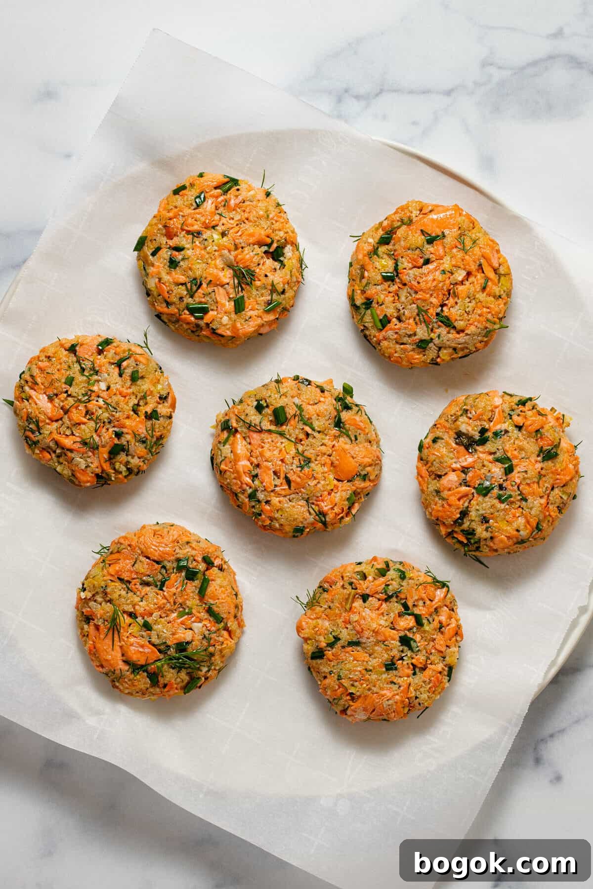 White plate with homemade salmon cakes just before frying