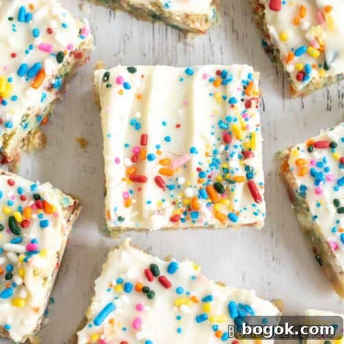 birthday cake blondies recipe spread out on white surface from overhead close up