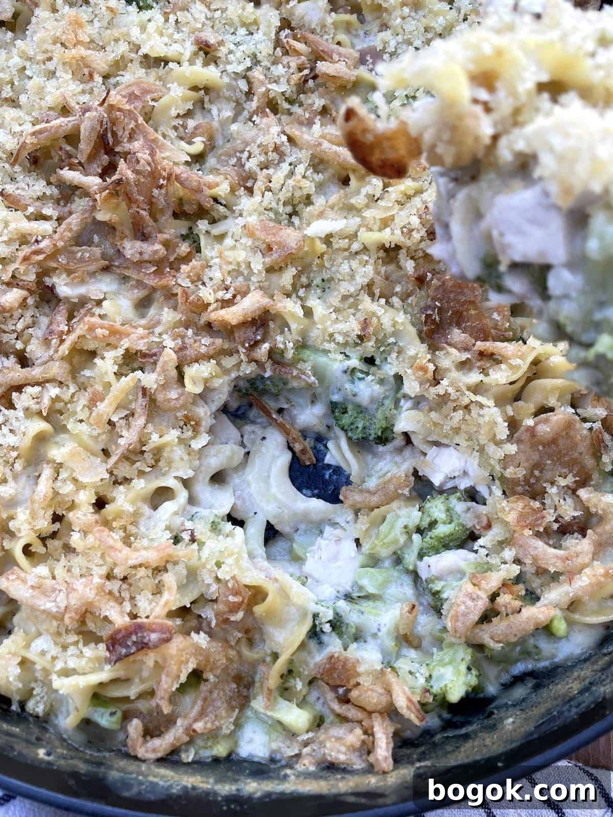 Baked Cheesy Chicken and Broccoli Noodle Casserole 7 A scoop of cheesy chicken noodle casserole being served and the inside of the casserole.
