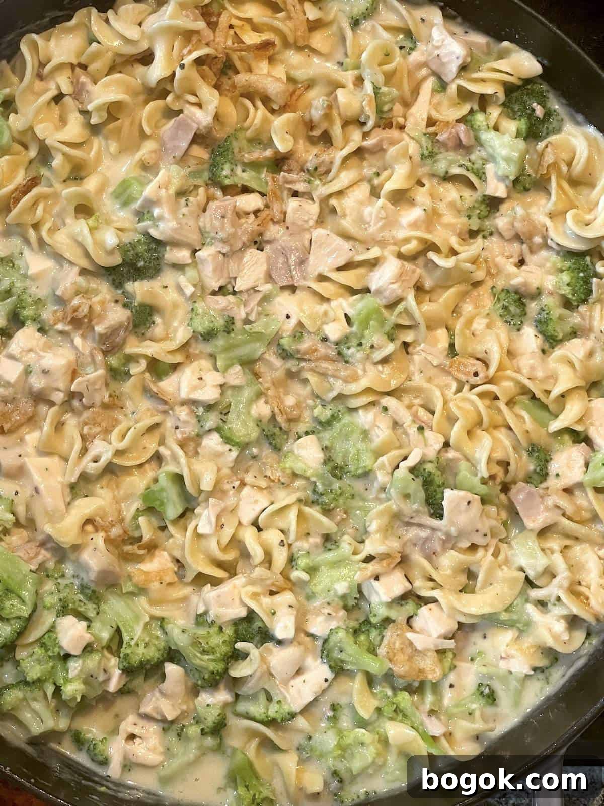 Baked Cheesy Chicken and Broccoli Noodle Casserole 5 A cast iron pan with cheesy chicken casserole in it before the topping is added.