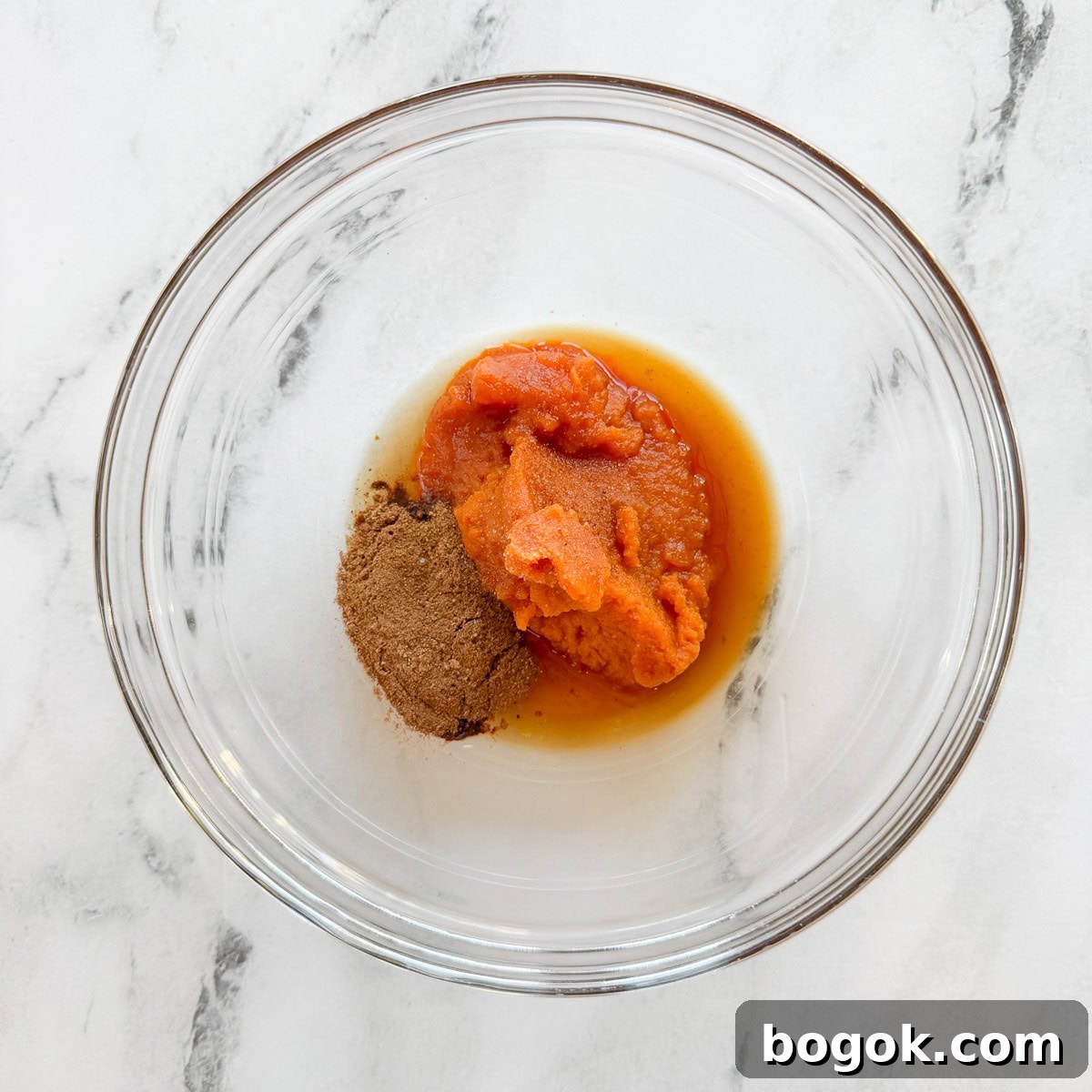 Pumpkin Overnight Oats Ready in 5 Minutes 4 Spices, pumpkin, and maple syrup in a glass bowl.