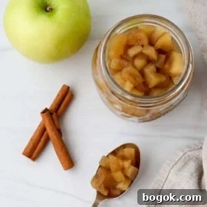 Homemade Apple Compote Recipe 9 Jar of apple compote next to an apple, cinnamon sticks and a spoonful of compote.