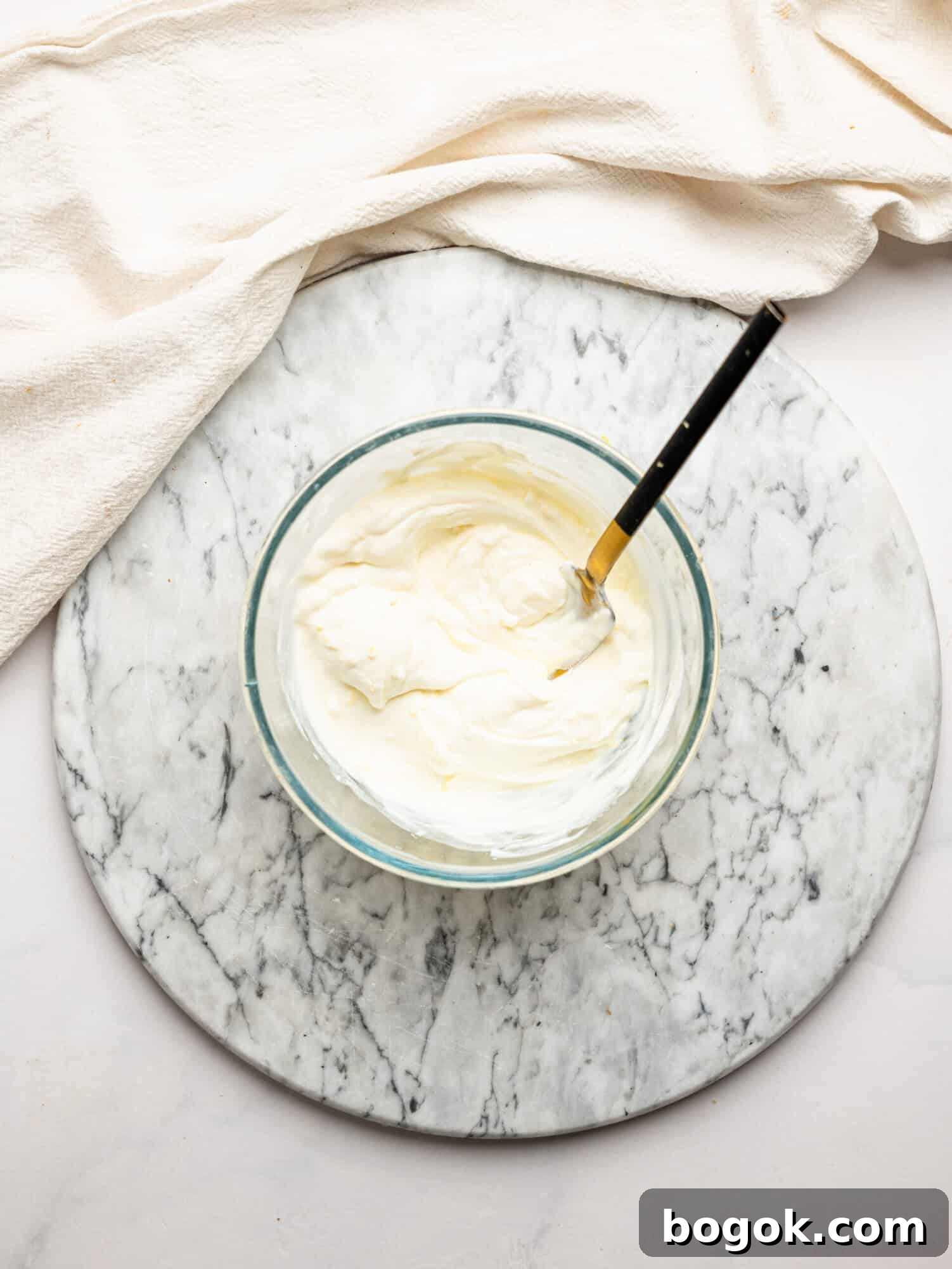 Lemon Cheesecake Overnight Weet-Bix Recipe 10 Smooth and creamy lemon cheesecake filling mixed in a glass bowl with a spoon.