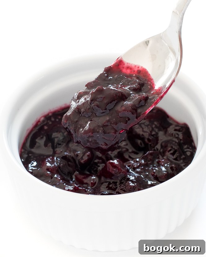 mixed berry compote in white ramekin with spoon