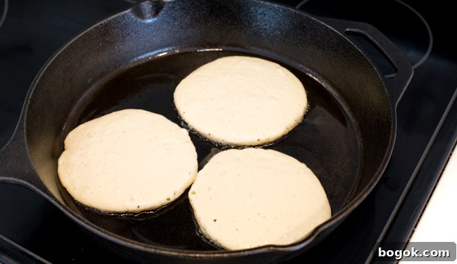 Cooking greek yogurt pancakes on a cast iron skillet in oil