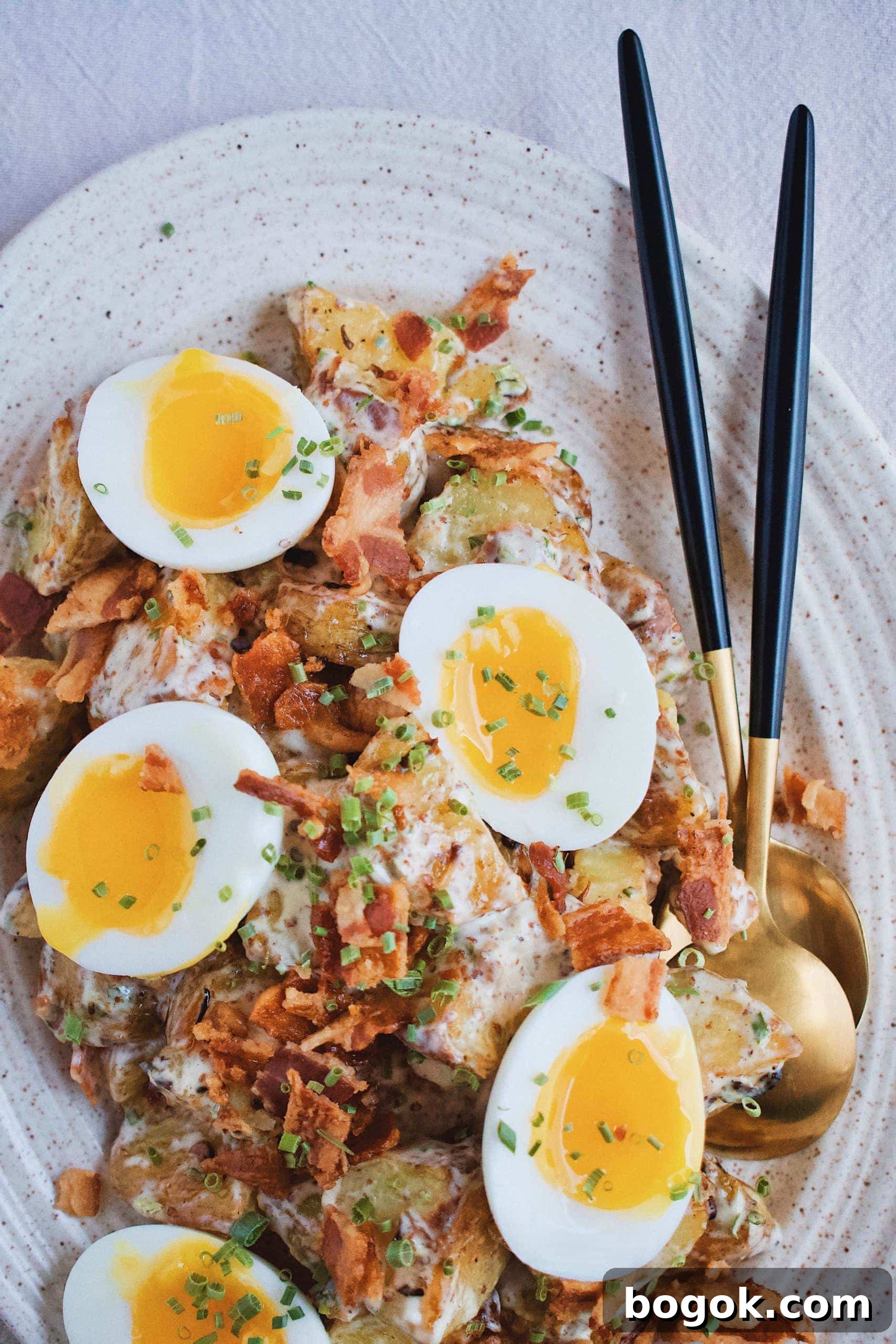 Crispy Roasted Potato Salad with Herbs and Dijon 2 Roasted Potato Salad on platter topped with runny boiled eggs.