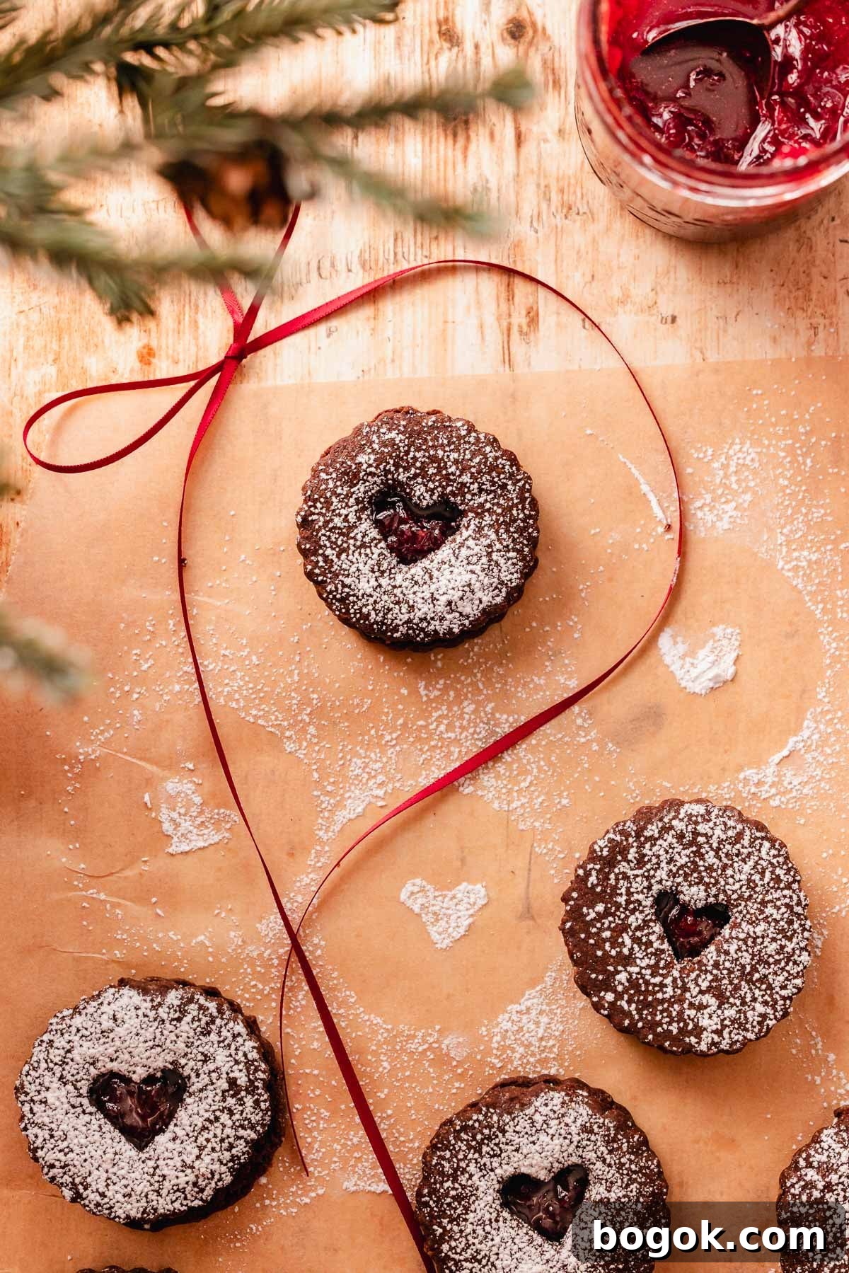 Chocolate Almond Cherry Linzer Cookies Recipe 15 chocolate cherry linzer cookie on parchment paper with a bow