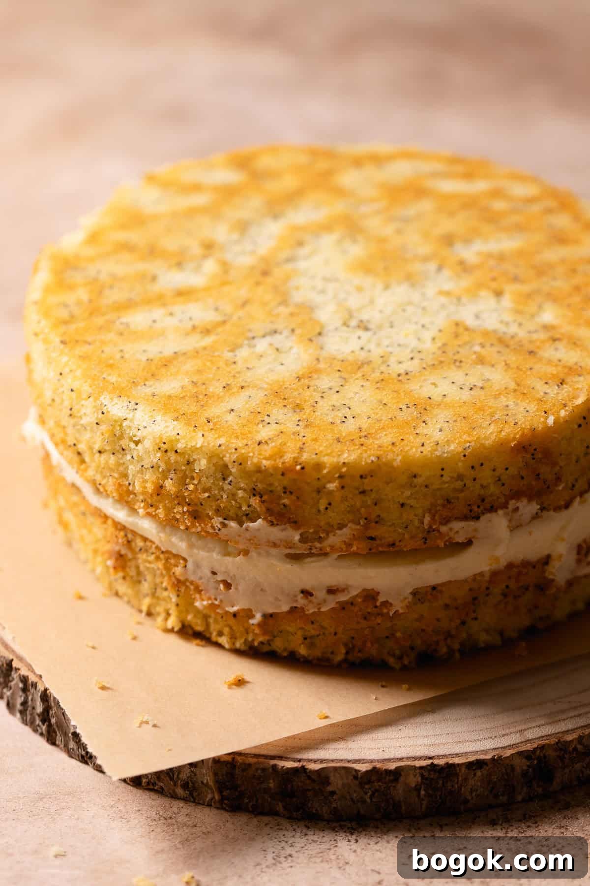 Lemon poppy cake with lemon curd center on a wooden platter with no frosting.
