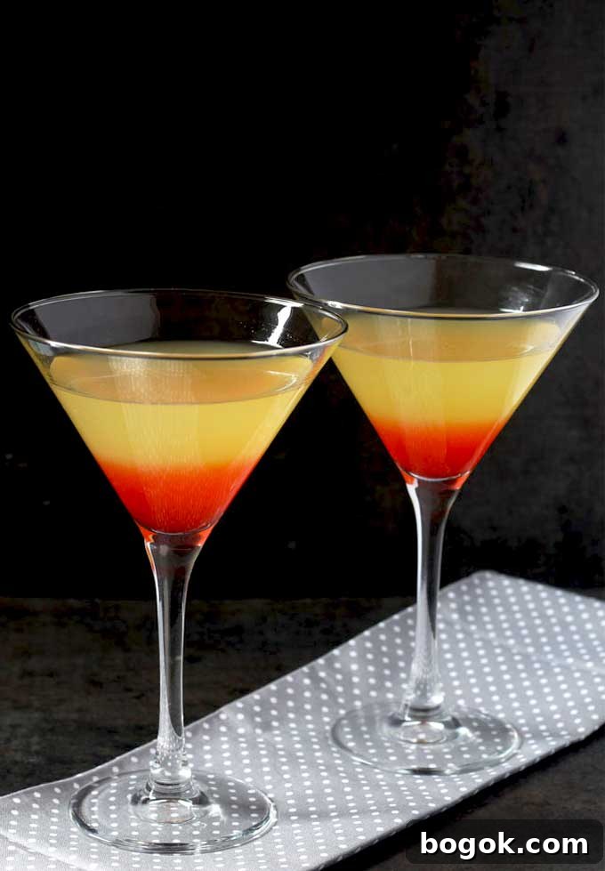 Bikini Martini Recipe: Pineapple Vodka Cocktail 3 Layered cocktail in martini glassed on a gray cloth