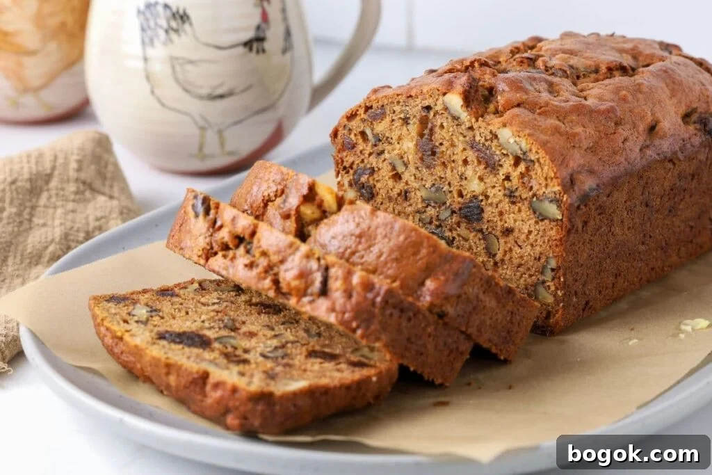 Sourdough date and walnut loaf cake sliced on a plate for serving.