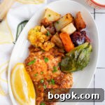 Last-Minute Rosh Hashanah Prep Guide 11 Harissa chicken and vegetables on a white plate with a slice of lemon.