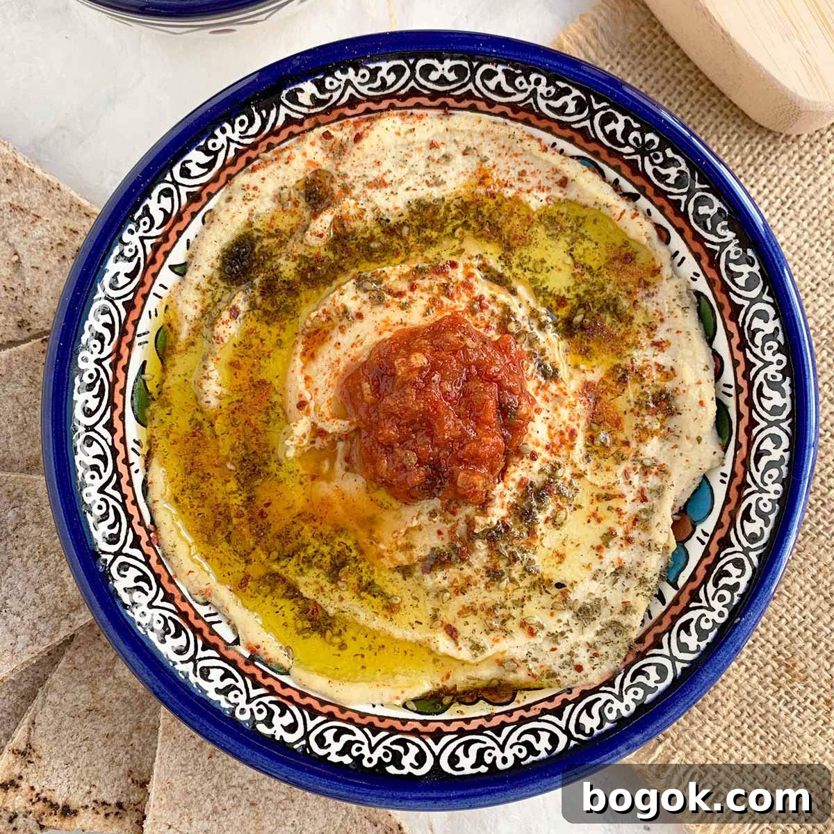 Last-Minute Rosh Hashanah Prep Guide 13 Top down view of preserved lemon hummus in blue bowl.