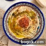 Last-Minute Rosh Hashanah Prep Guide 14 Top down view of preserved lemon hummus in blue bowl.