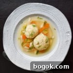 Last-Minute Rosh Hashanah Prep Guide 19 matzo ball soup in white bowl on dark brown background