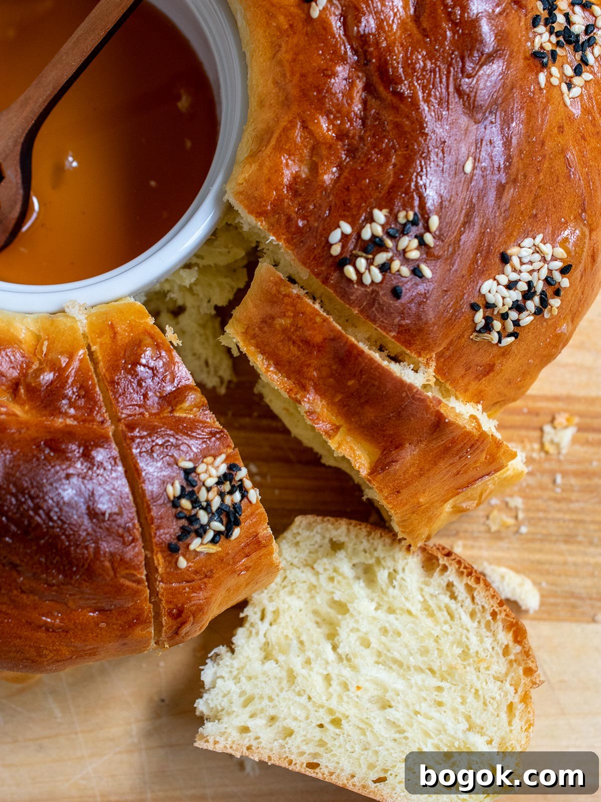 Last-Minute Rosh Hashanah Prep Guide 20 Close up of round challah with a slice face up and part of the honey ramekin showing.