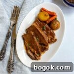 Last-Minute Rosh Hashanah Prep Guide 4 Sliced brisket on a small white plate with potatoes and carrots.