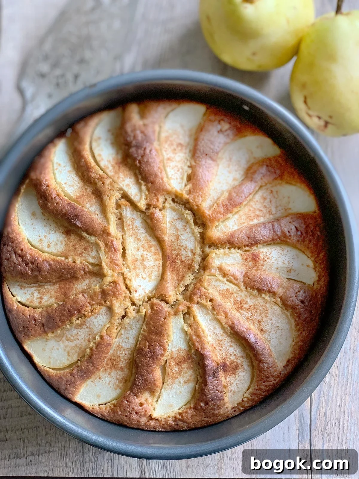 Last-Minute Rosh Hashanah Prep Guide 32 Pear cake still in baking pan with some whole pears on the side.