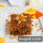 Last-Minute Rosh Hashanah Prep Guide 33 Honey orange cake on a white plate with slices of citrus in the background.