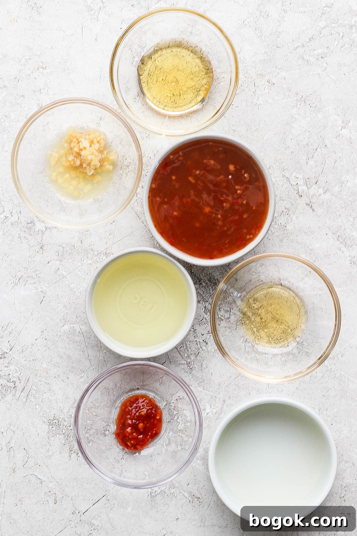 Sweet Chili Vinaigrette for Salads and Marinades 3 Individual bowls of honey, minced garlic, sweet chili sauce, olive oil, rice vinegar, sesame oi, and garlic chili sauce.