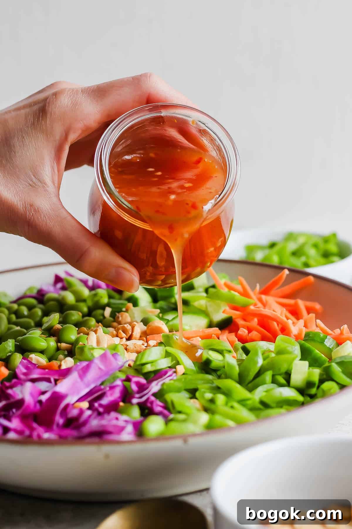 Sweet Chili Vinaigrette for Salads and Marinades 5 Sweet chili vinaigrette being poured over a chopped pea salad.