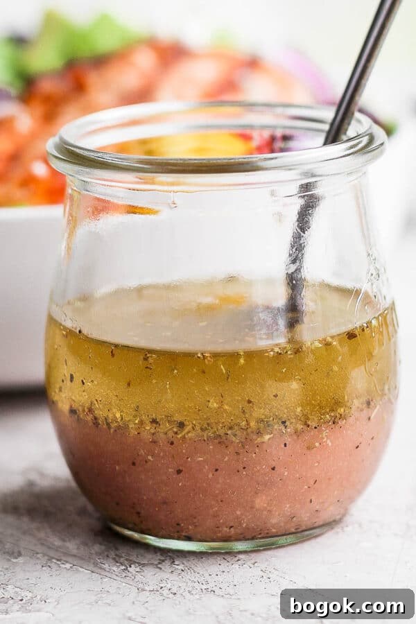 Greek vinaigrette in a small jar with a spoon.
