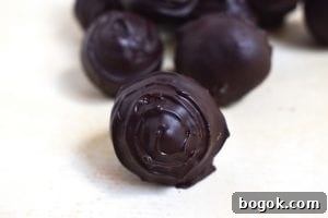 Tim Tam Cheesecake Truffles Recipe - No-Bake Bite-Sized Treats 2 Close up of a chocolate covered Tim Tam Cheesecake Truffles. These are sweet and creamy Tim Tam cheesecake with the distinct flavour of chocolate Tim Tams. If you love Tim Tams and cheesecake you will love these truffles. #timtams #timtamcheesecake