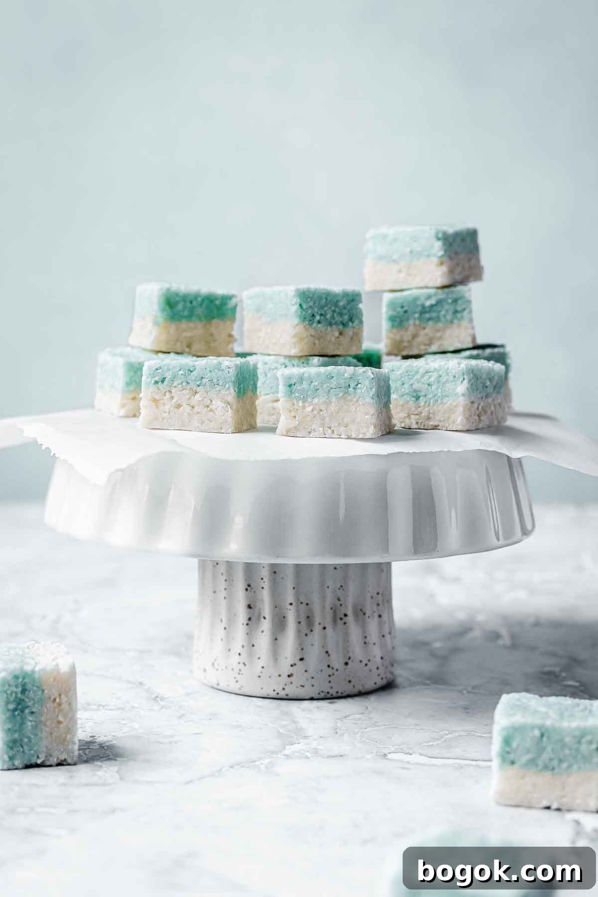 Classic Pink Coconut Ice Candy Recipe 2 Blue and white candy squares on a white cake stand.
