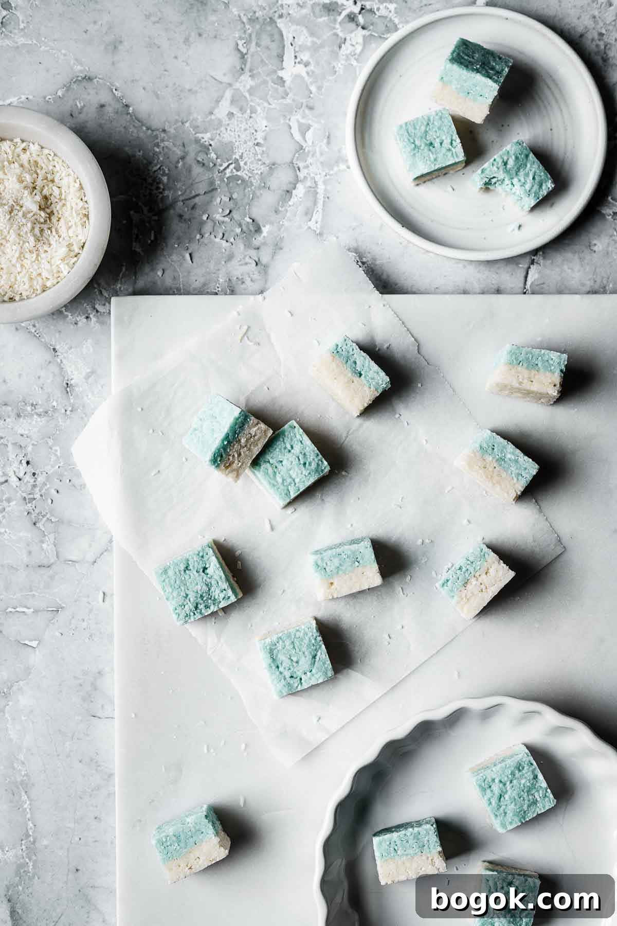 Classic Pink Coconut Ice Candy Recipe 12 Squares of coconut candy on a white marble tray.