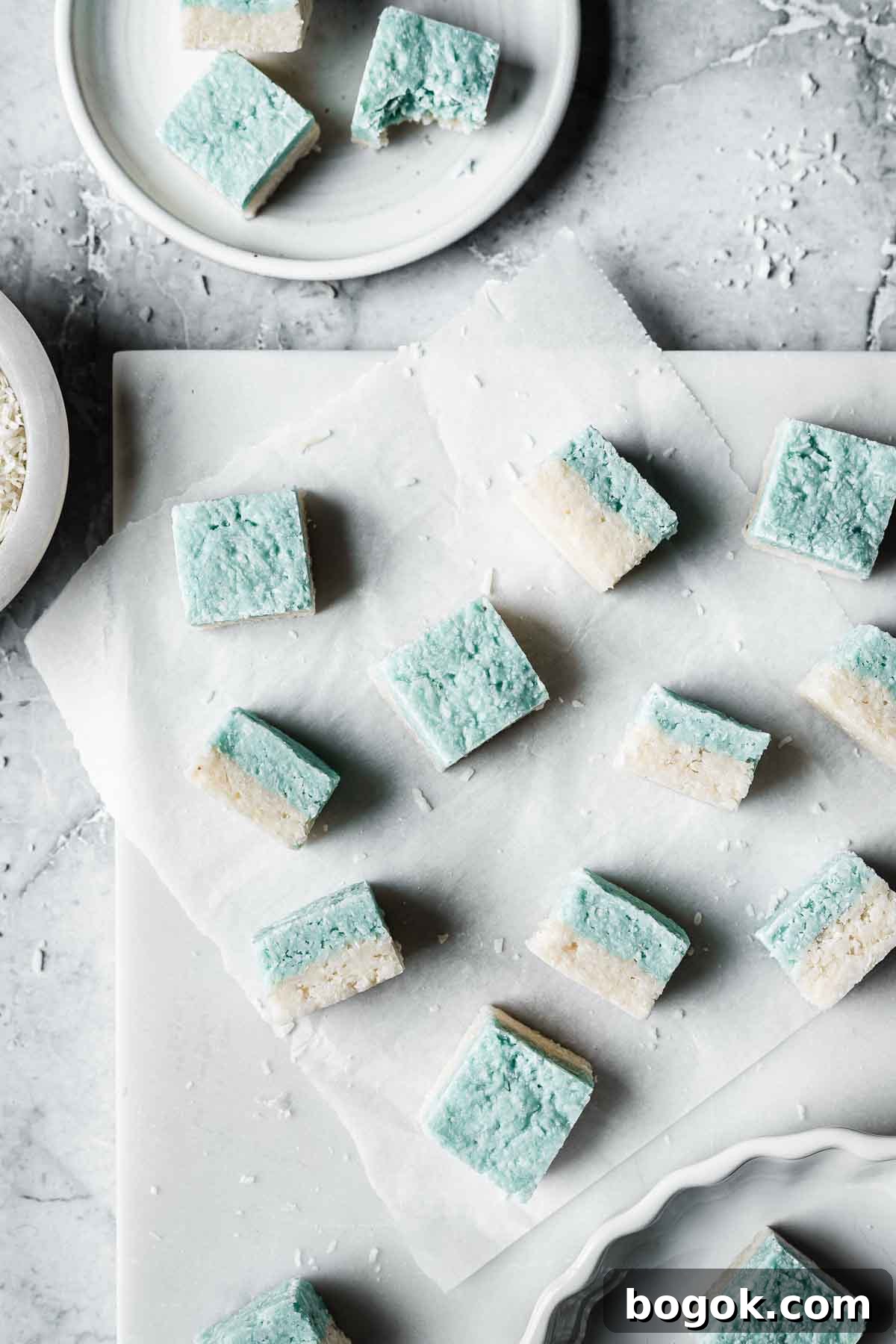 Classic Pink Coconut Ice Candy Recipe 3 Squares of blue and white candy on a white marble tray.